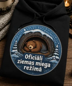Hūdijs ar apaļu ziemas nozīmītes dizainu: guļošs lācis alā un teksts Oficiāli ziemas miega režīmā